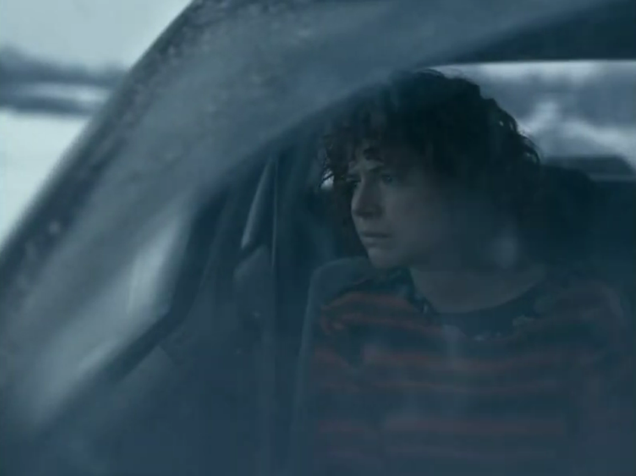 An image of a woman staring out a car window